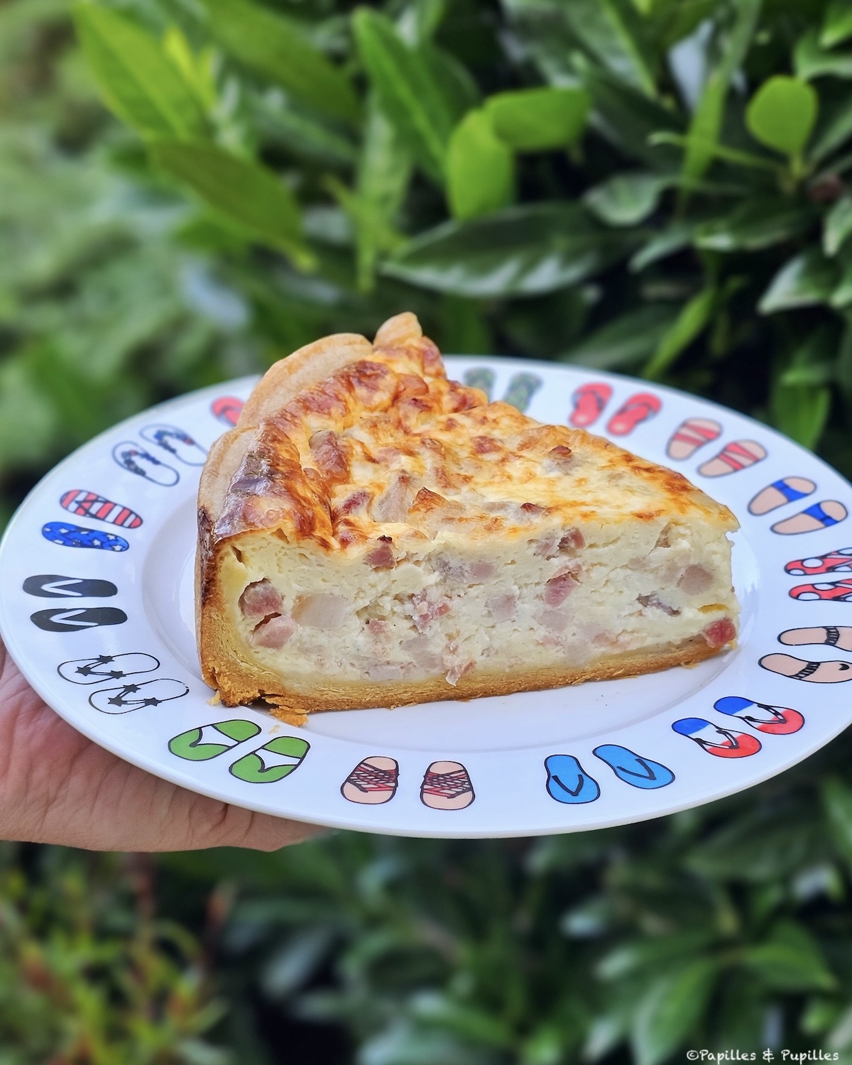 Part de quiche lorraine traditionnelle servie à table, migaine bien prise et pâte croustillante