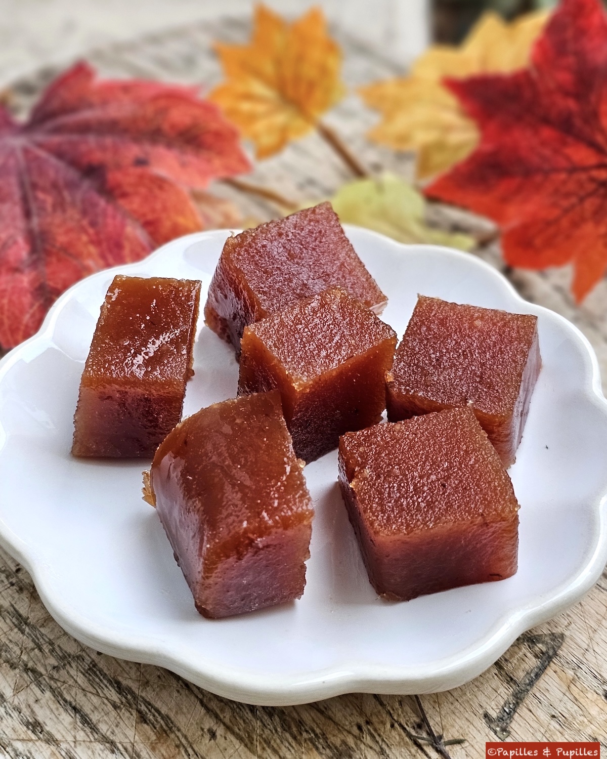 Carrés de pâte de coings dans une petite assiette. Décor d'automne