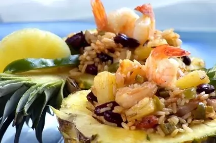 Présentation du wok d’ananas au curry dans une demi coque d’ananas