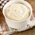 Mayonnaise in a bowl on wooden background.