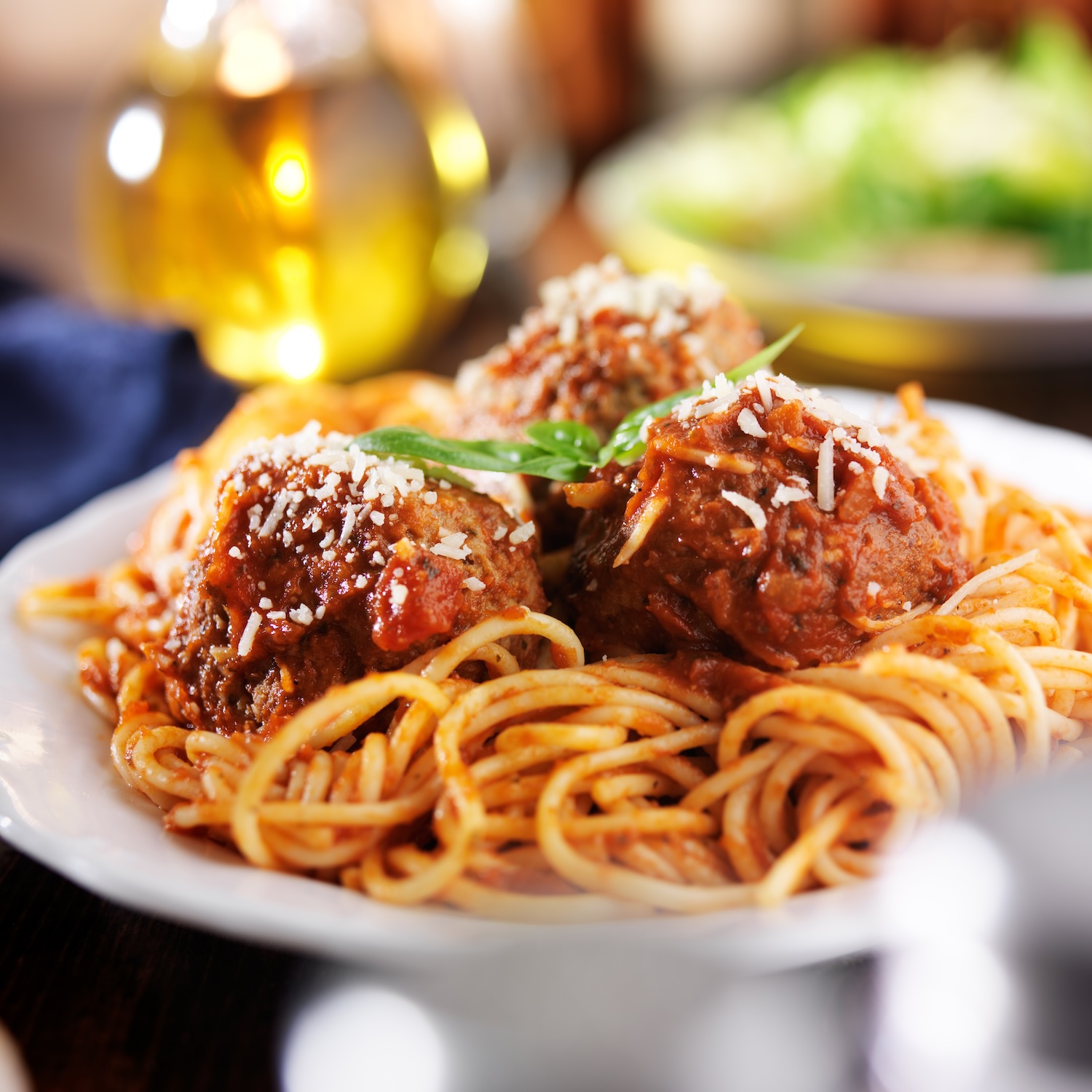 Italian spaghetti and meatballs with salad in background