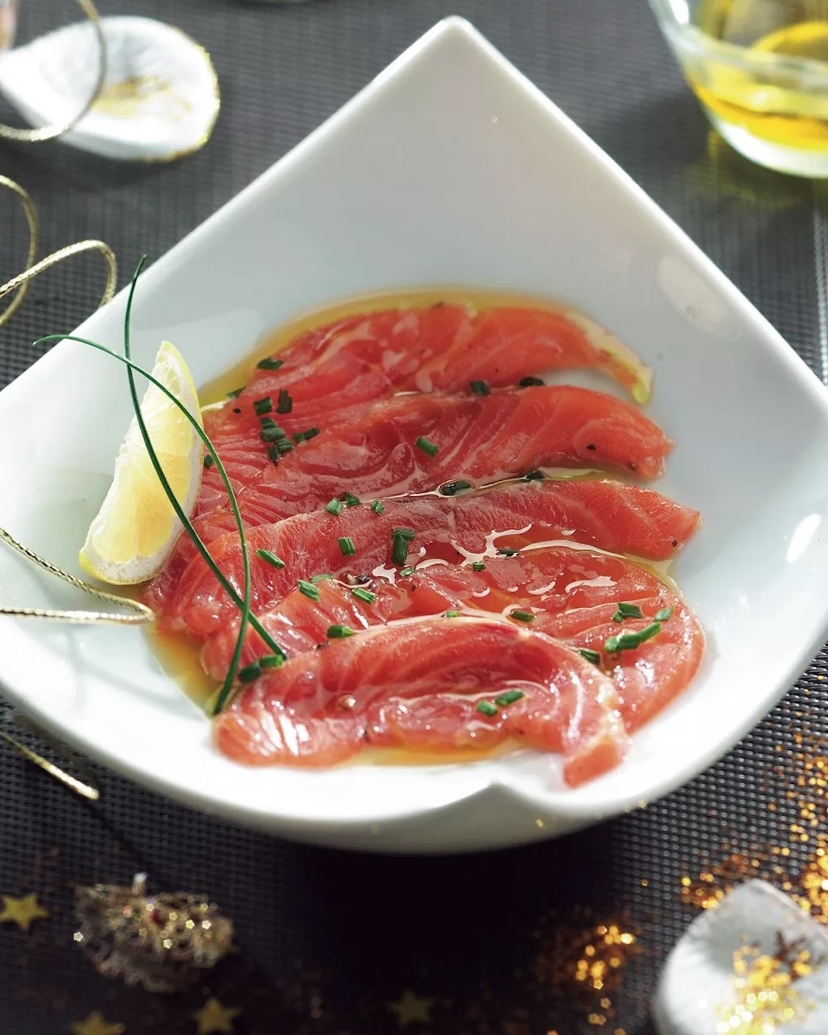 Saumon cru mariné à l’huile d’olive, citron et ciboulette, servi en fines tranches