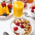 Healthy Breakfast Meal - Bowl of Fruit, Oat and Nut Granola with Yogurt and Raspberries
