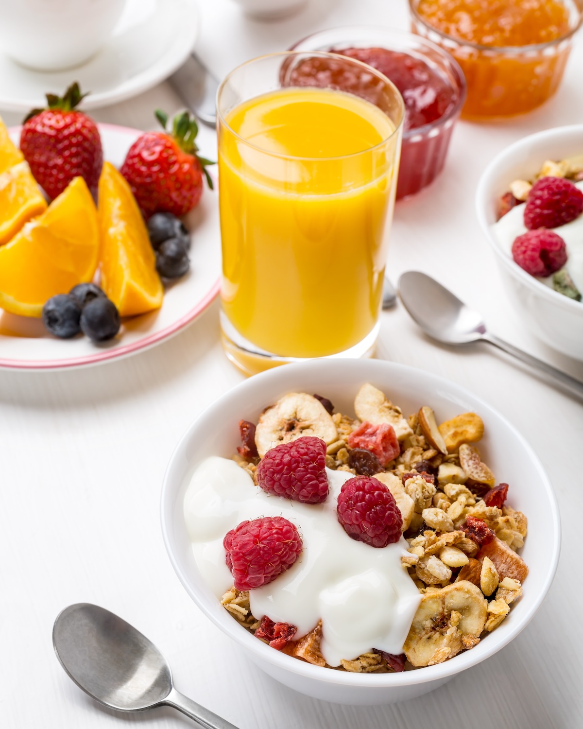 Healthy Breakfast Meal - Bowl of Fruit, Oat and Nut Granola with Yogurt and Raspberries