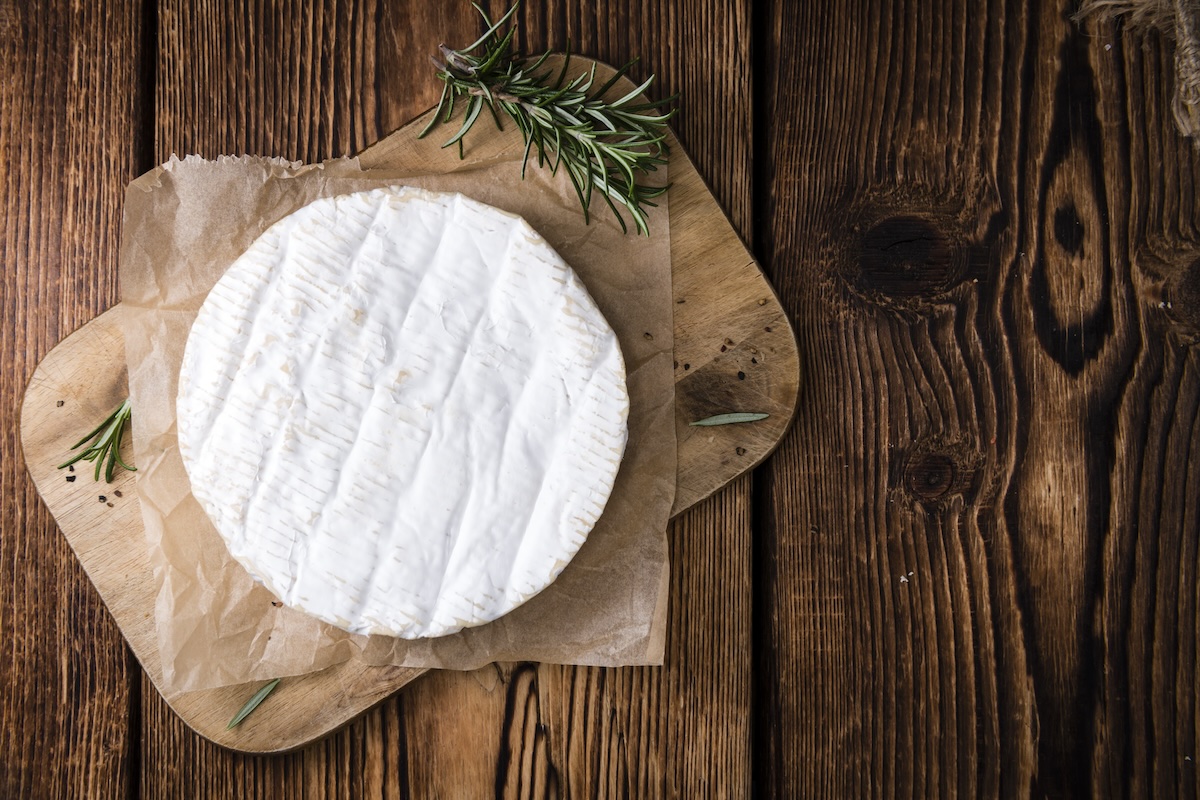 Creamy Camembert (close-up shot) on wooden background
