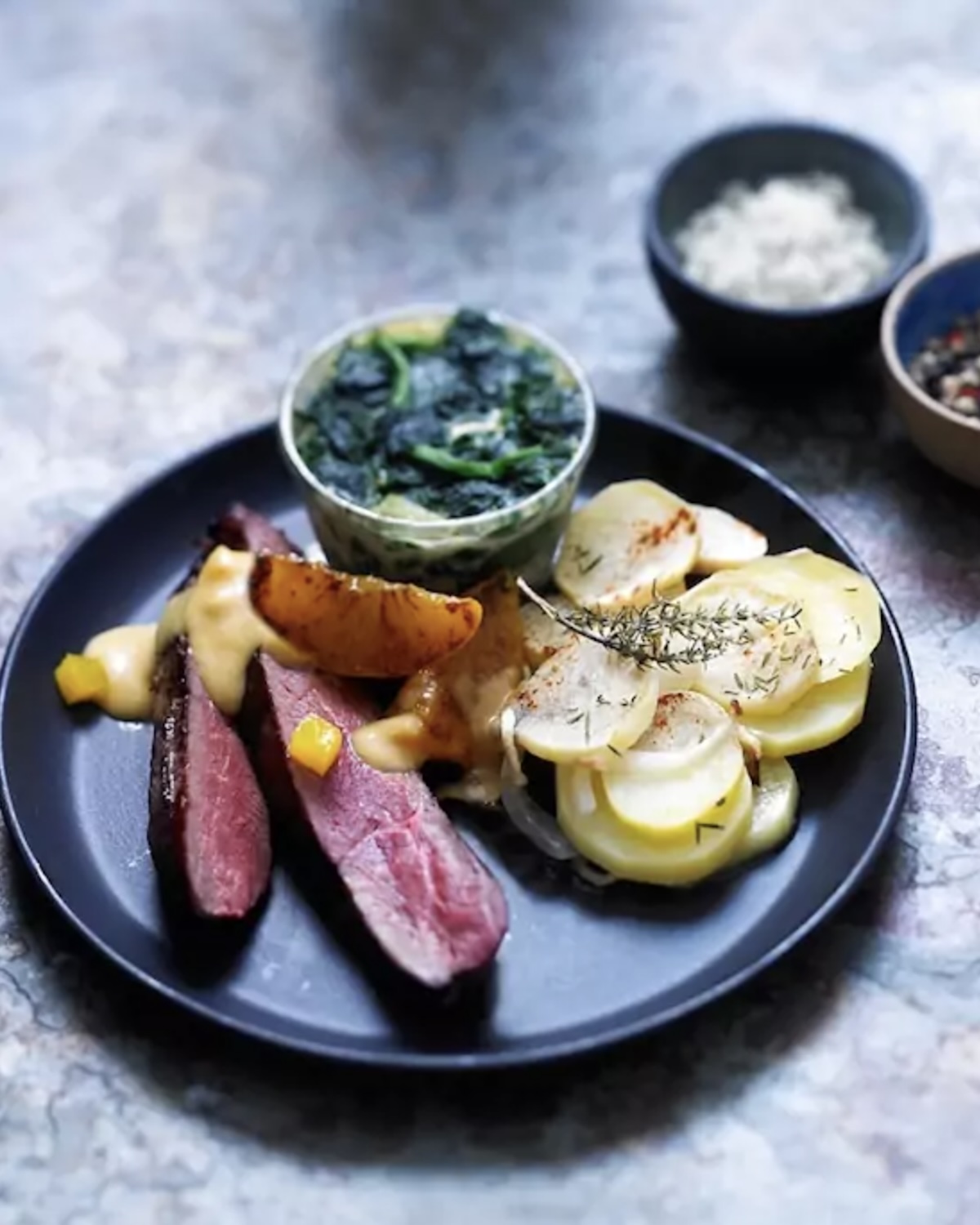 Filet de canard rôti aux pêches, épinards et pommes boulangères