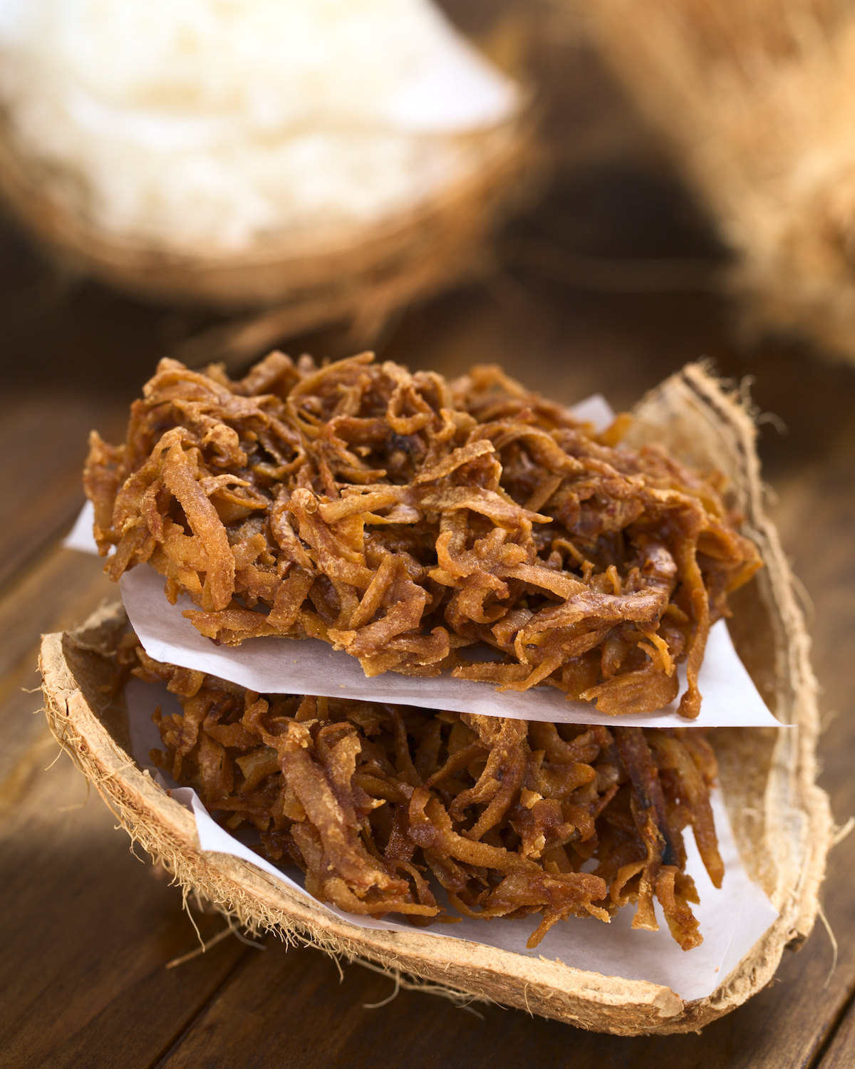 Peruvian cocadas, a traditional coconut dessert sold usually on the streets, made of grated coconut and brown sugar, which gives the coloring of it (Selective Focus, Focus on the front of the cocadas)