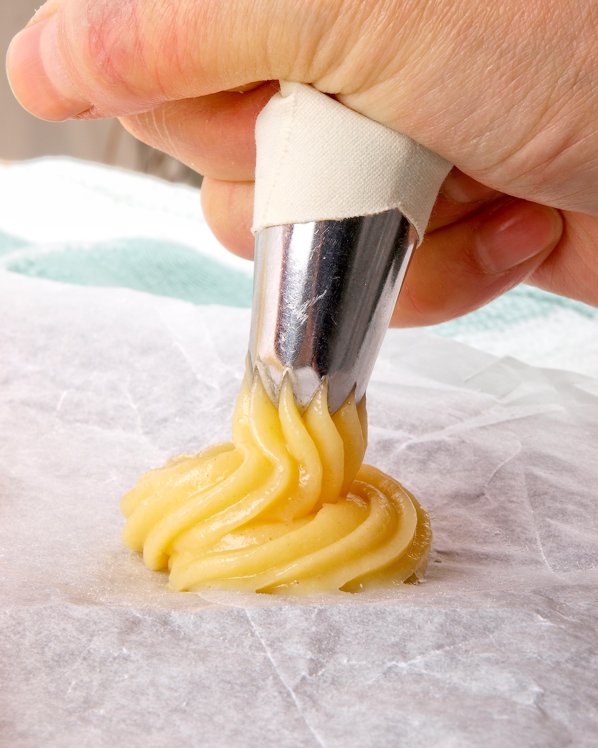 Petits tas de pâte à choux pochés régulièrement sur une plaque, juste avant d’enfourner (photo Shutterstock)