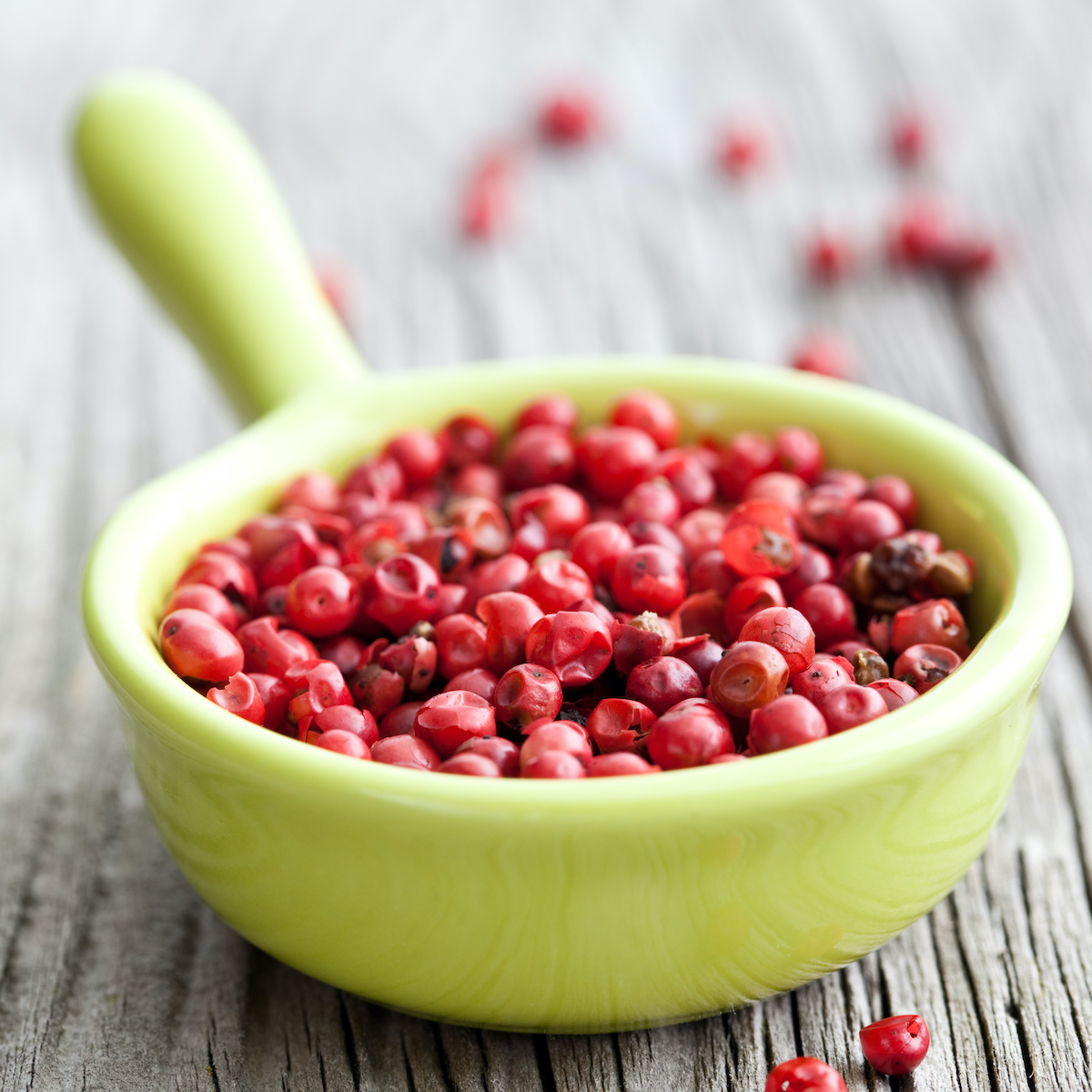 pink pepper in green bowl