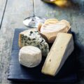 Various types of cheese and white wine on wooden background