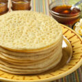 Heap of Moroccan beghrir pancakes served with honey and butter