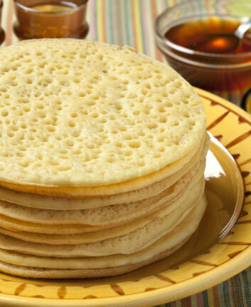 Heap of Moroccan beghrir pancakes served with honey and butter