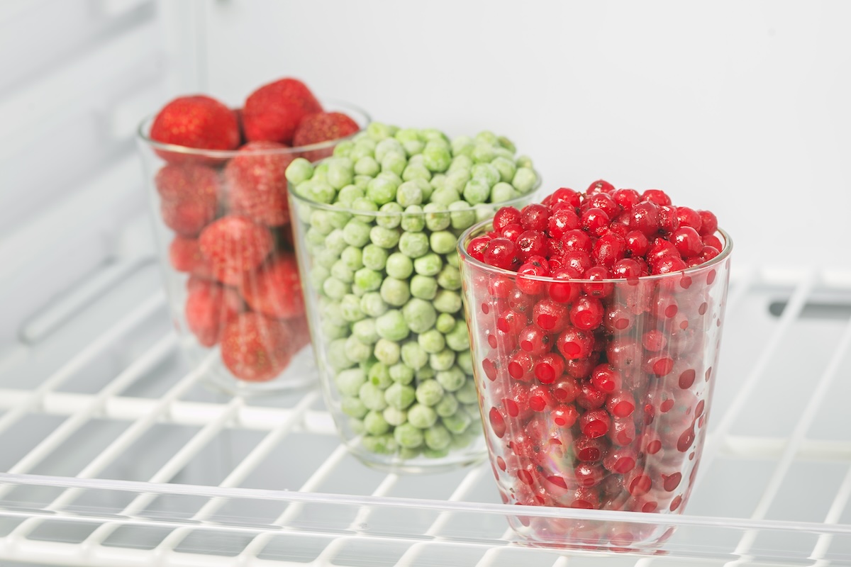 Frozen food in the freezer, red currants, strawberries and green peas