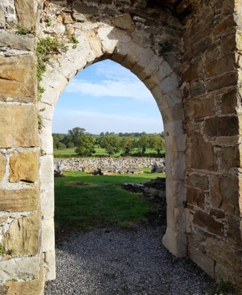Arche en pierre de Newtown Jerpoint ouvrant sur la campagne verdoyante irlandaise