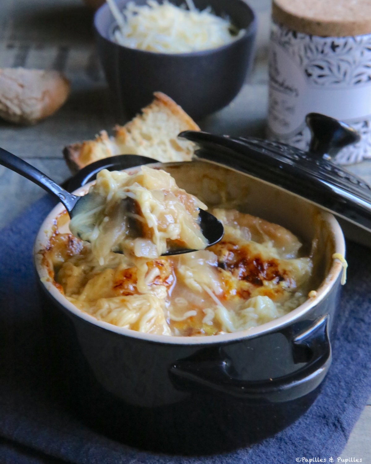 Soupe à l’oignon gratinée avec fromage filant, servie dans un bol, très chaude, parfaite pour un dîner d’hiver