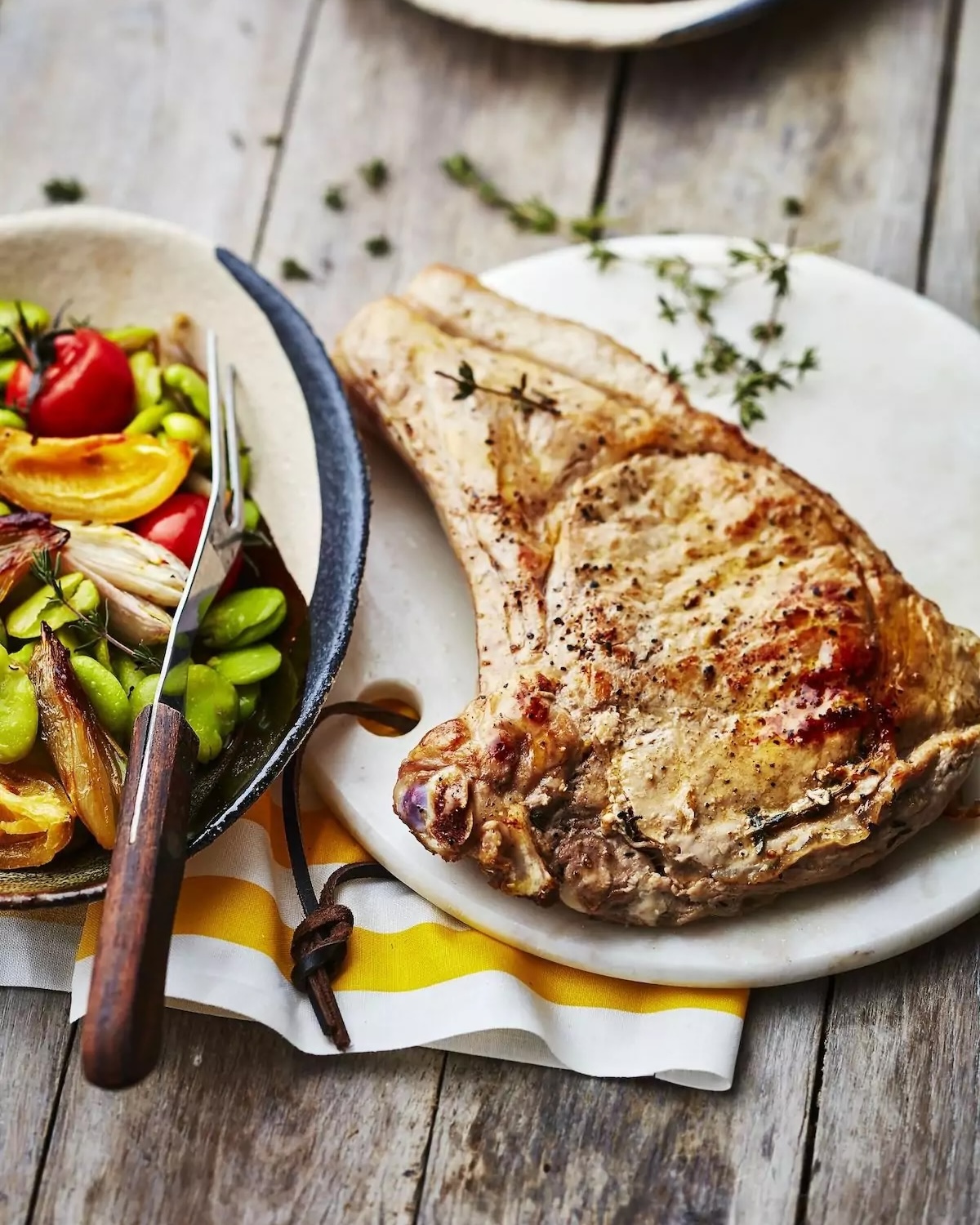 Côtes de veau à la poêle servies avec fèves, tomates cerises et citron confit