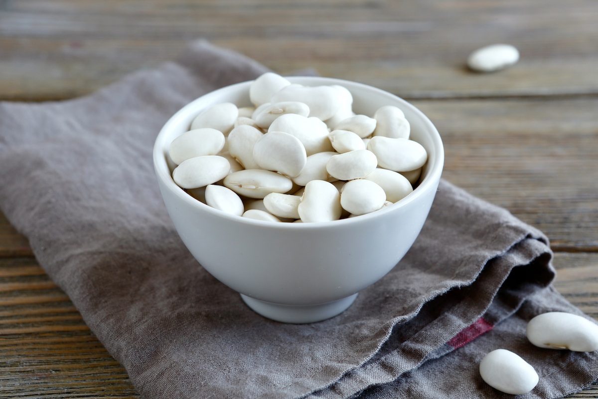 Haricots secs de différentes couleurs étalés sur un plan de travail