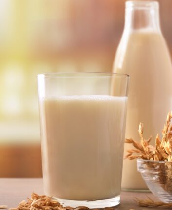 Spelled drink in containers with spikes on a wooden table in a rustic kitchen. Vertical composition. Front view