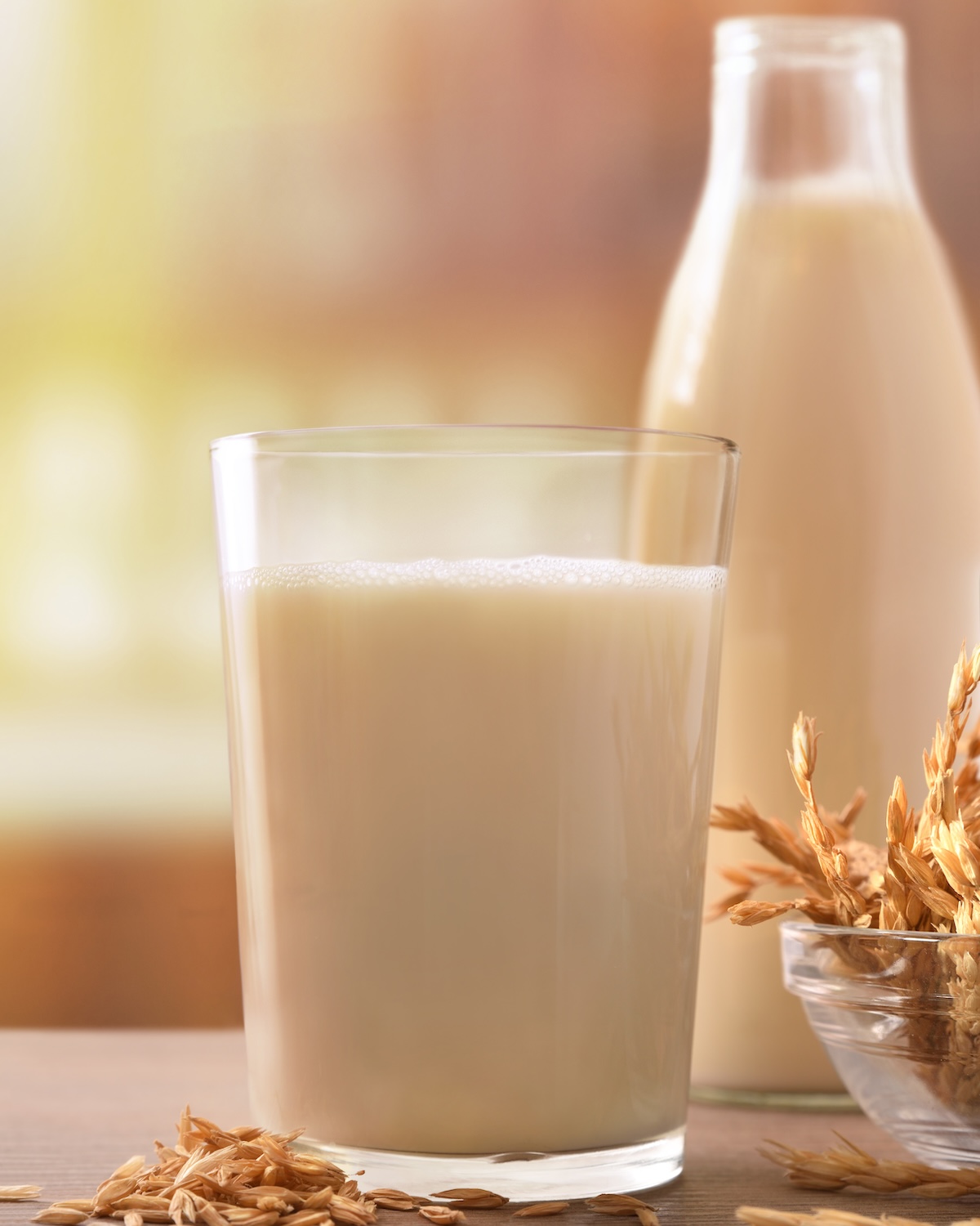 Spelled drink in containers with spikes on a wooden table in a rustic kitchen. Vertical composition. Front view