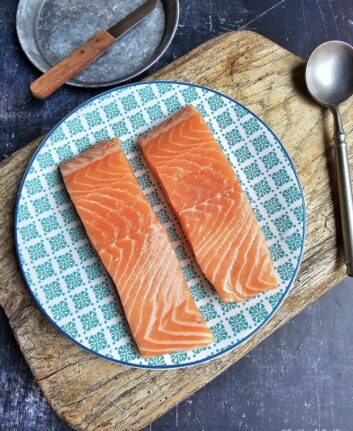 2 pavés de saumon dans une assiette bleue.