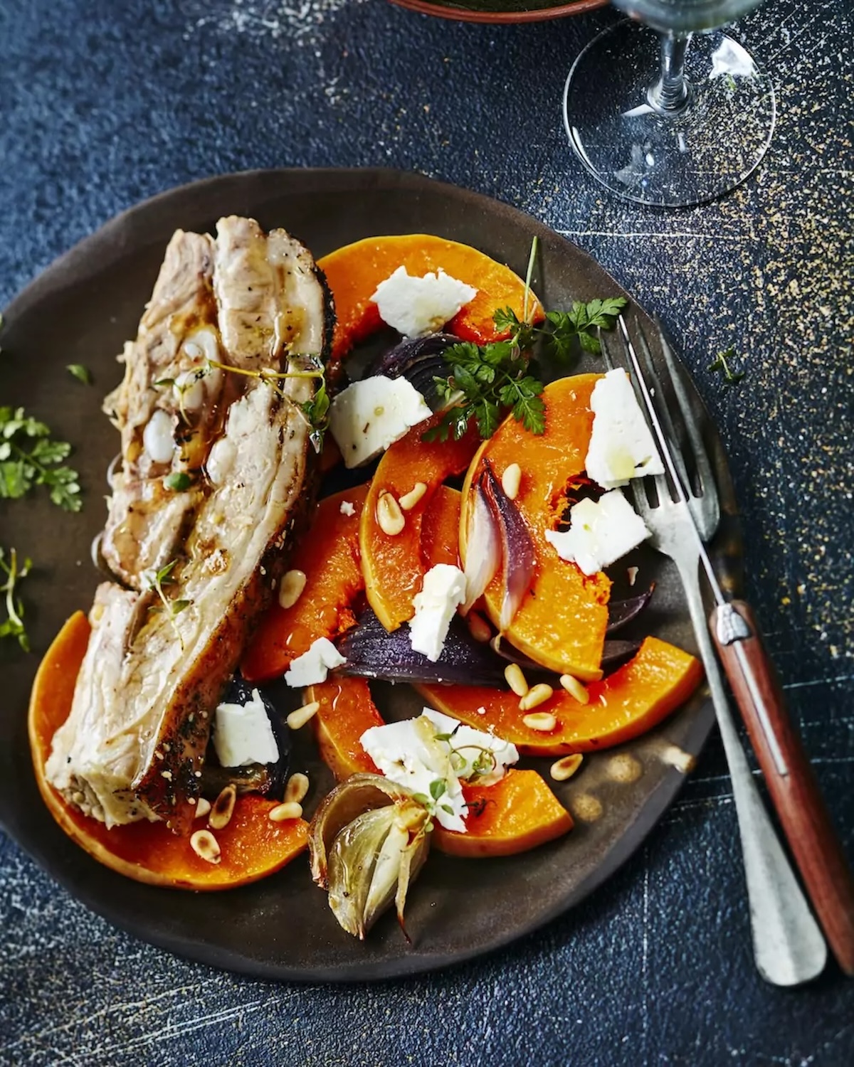 Tendrons de veau rôtis au four, servis avec des tranches de butternut dorées, de la féta émiettée et quelques pignons grillés, dans un plat familial aux couleurs d’automne.