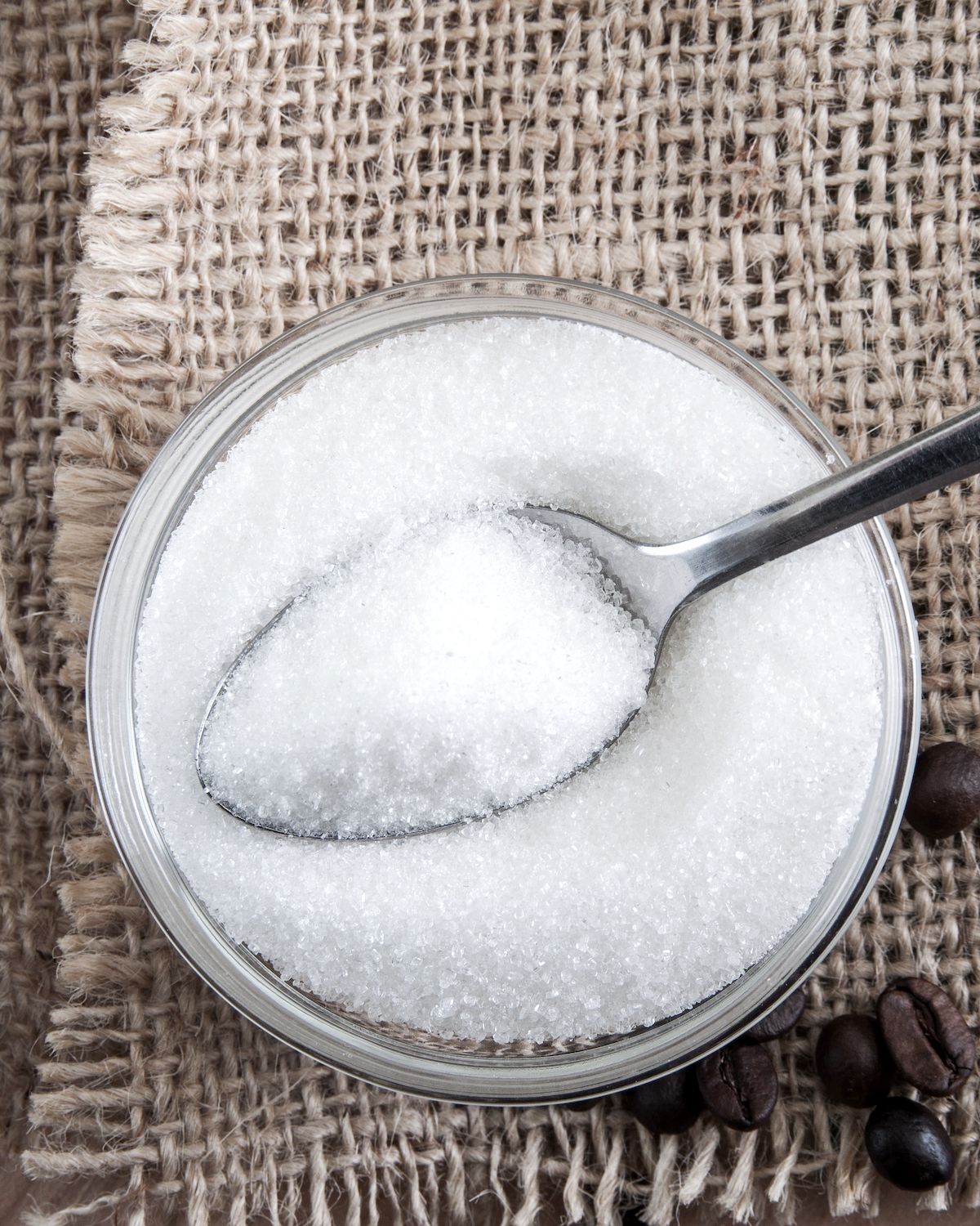 Spoon in a glass bowl of sugar, close up