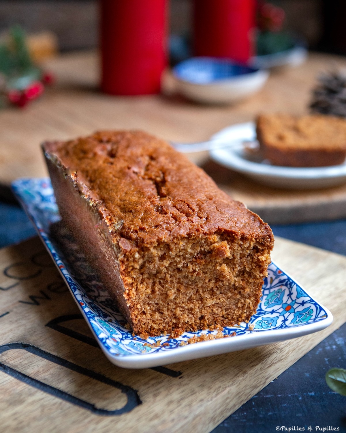 Pain d’épices maison posé sur un plat bleu, tranché, ambiance de fêtes