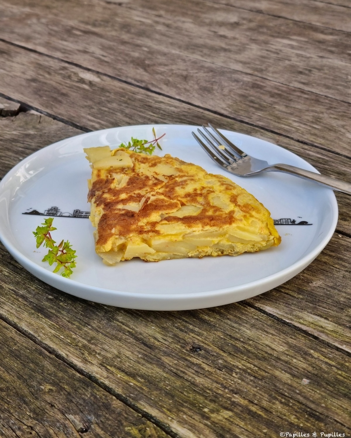 Tortilla de patatas espagnole, épaisse et fondante, servie dans une assiette en céramique