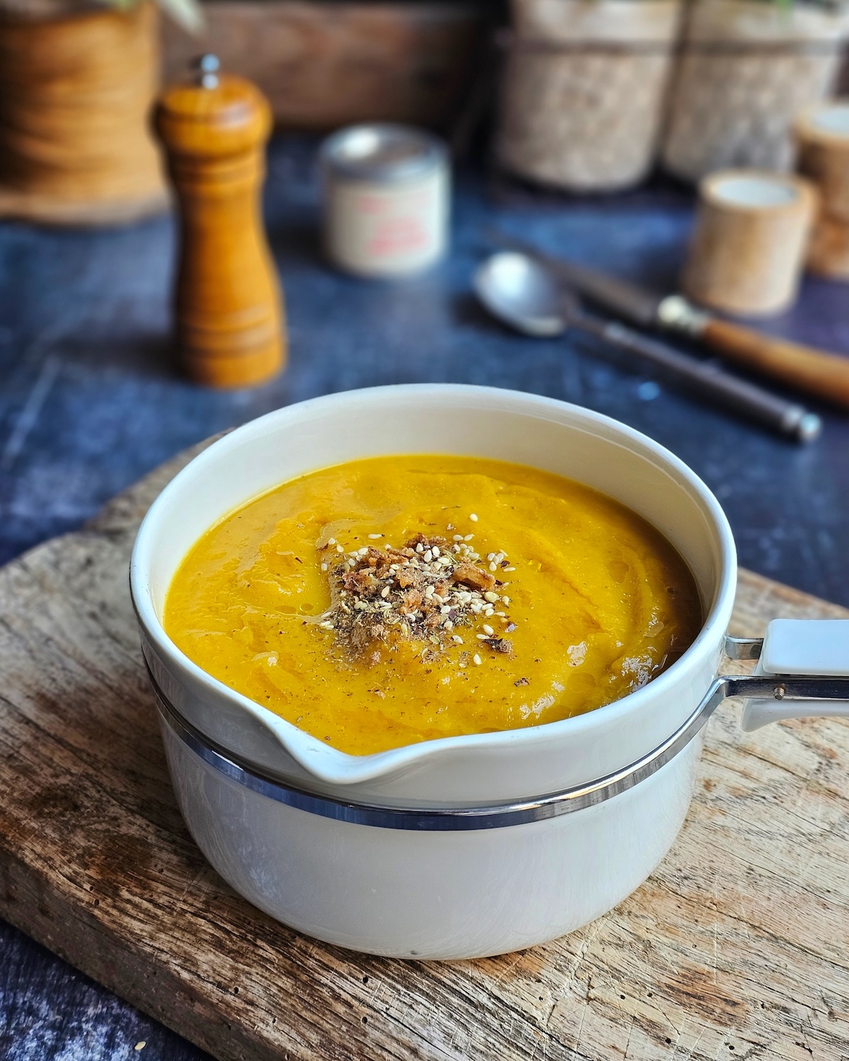 Soupe poireaux carottes très mixée, servie dans un bol avec garniture