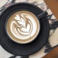 Latte au sésame noir prêt à boire. Tasse posée sur une table en marbre