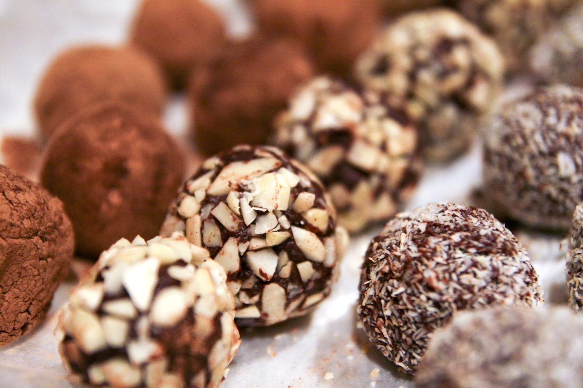 Truffes au chocolat maison, roulées à la main et présentées pour les fêtes de Noël, sur fond simple et gourmand