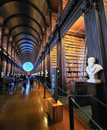 La Long Room de Trinity College, galerie de bois sombre, rangées de livres anciens et voûte impressionnante