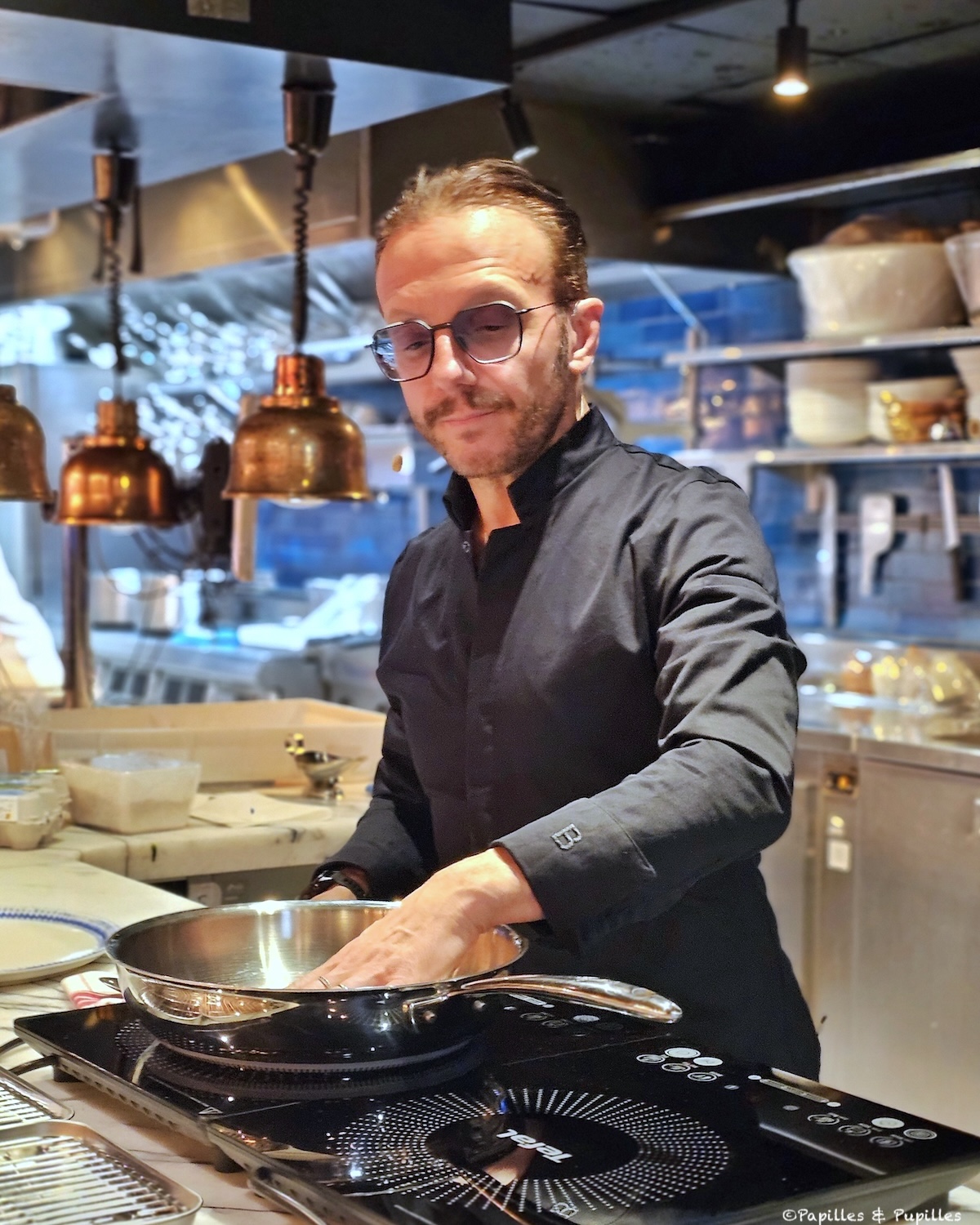 Chef Simone Zanoni en démonstration avec une poêle en inox