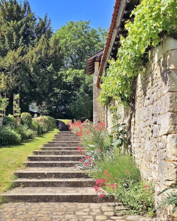 Escalier, mur en tuffeau et végétation dans les extérieurs de La Devinière, maison de Rabelais