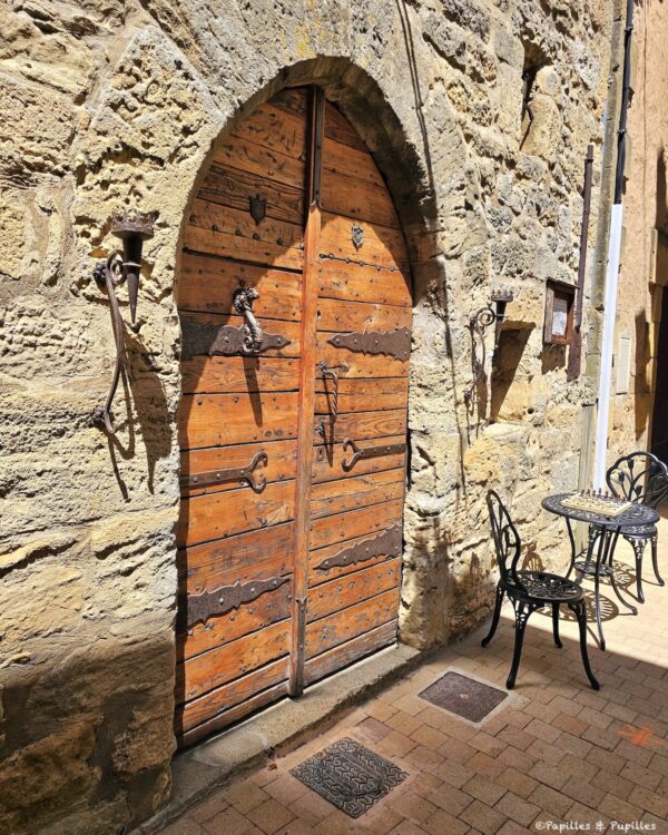 Porte ancienne en bois et ferronneries dans une ruelle de Belvès