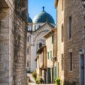 Rue en pente de Castelnau-Montratier avec l’église Saint-Martin et sa coupole bleue en arrière-plan