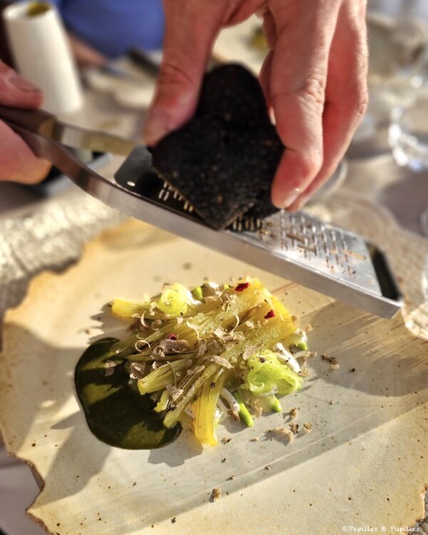 Celtuce servie avec une sauce verte et de la truffe fraîche râpée à table au restaurant Le 1862