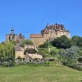 Château de Biron dominant le village et la campagne du Périgord sous un grand ciel bleu