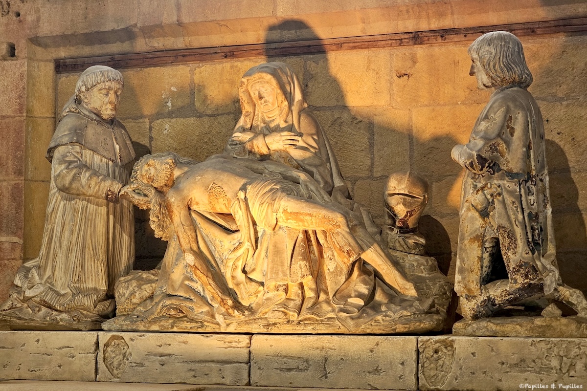 Piéta sculptée dans la chapelle du Château de Biron, éclairée par une lumière chaude