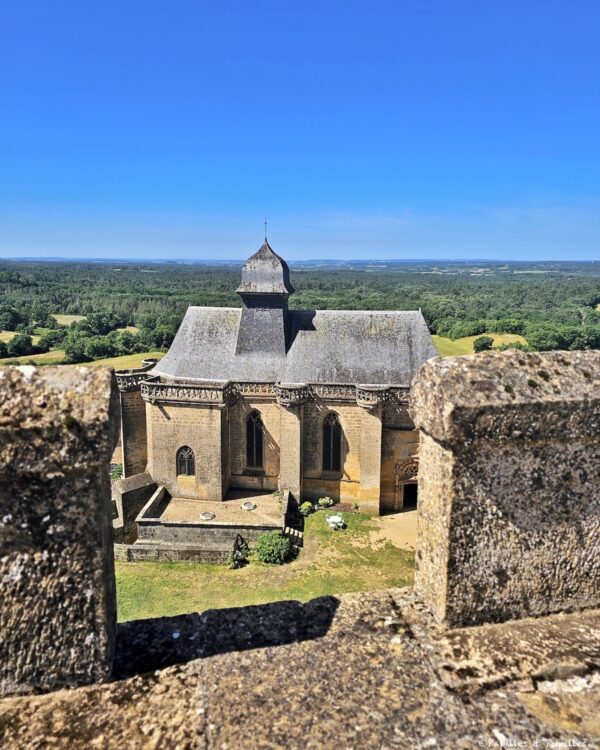 Chapelle du Château de Biron vue depuis les remparts avec la forêt du Périgord en arrière-plan
