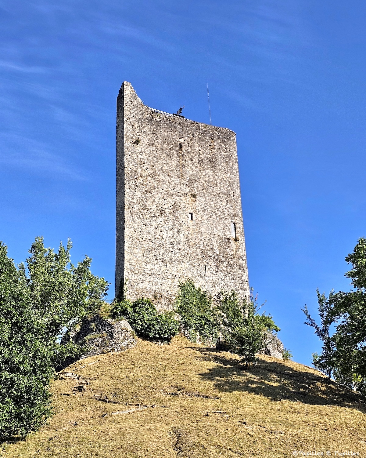 Donjon médiéval de Montcuq-en-Quercy-Blanc sous un ciel bleu