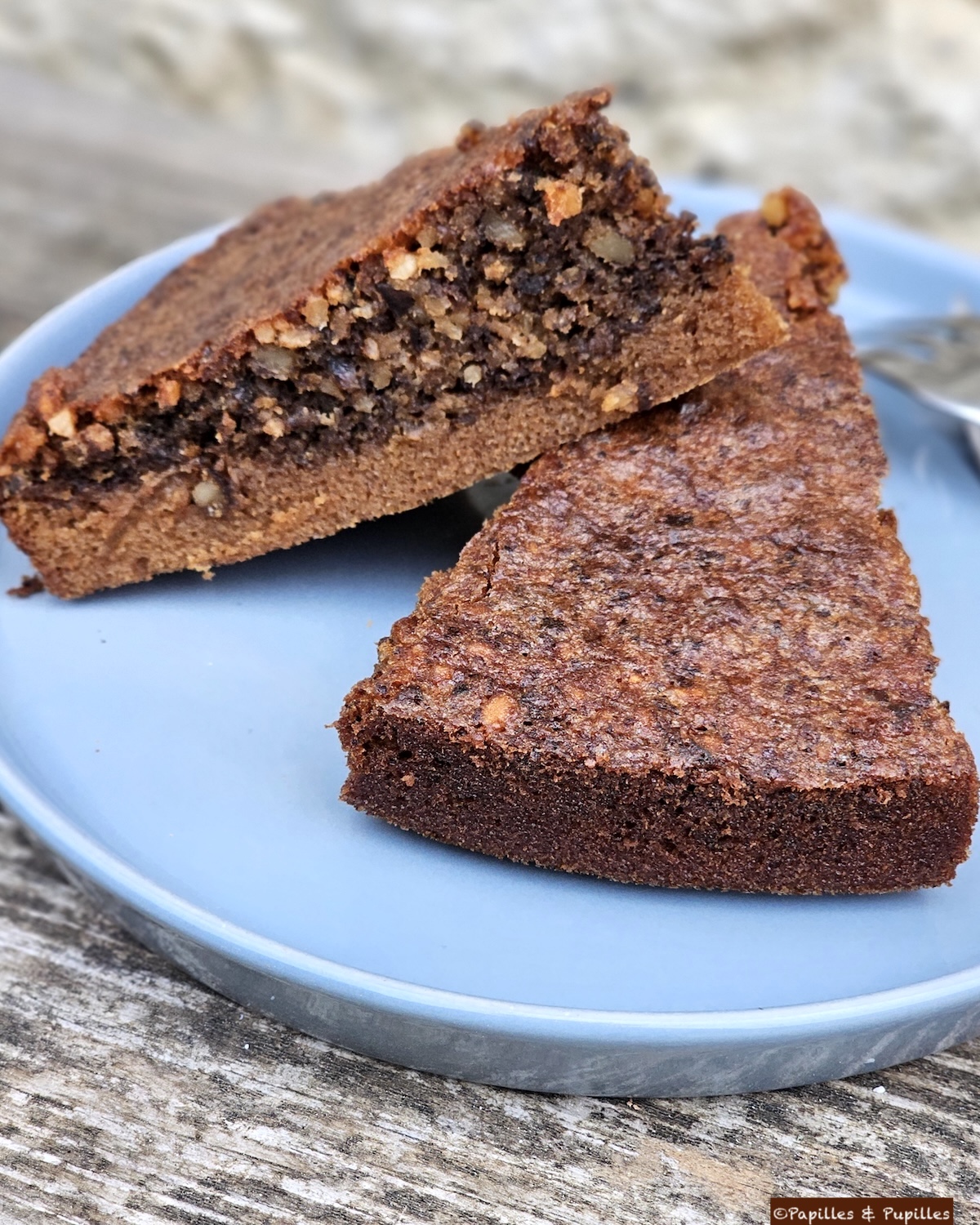 Parts de gâteau au chocolat et aux noix servies sur une assiette bleue