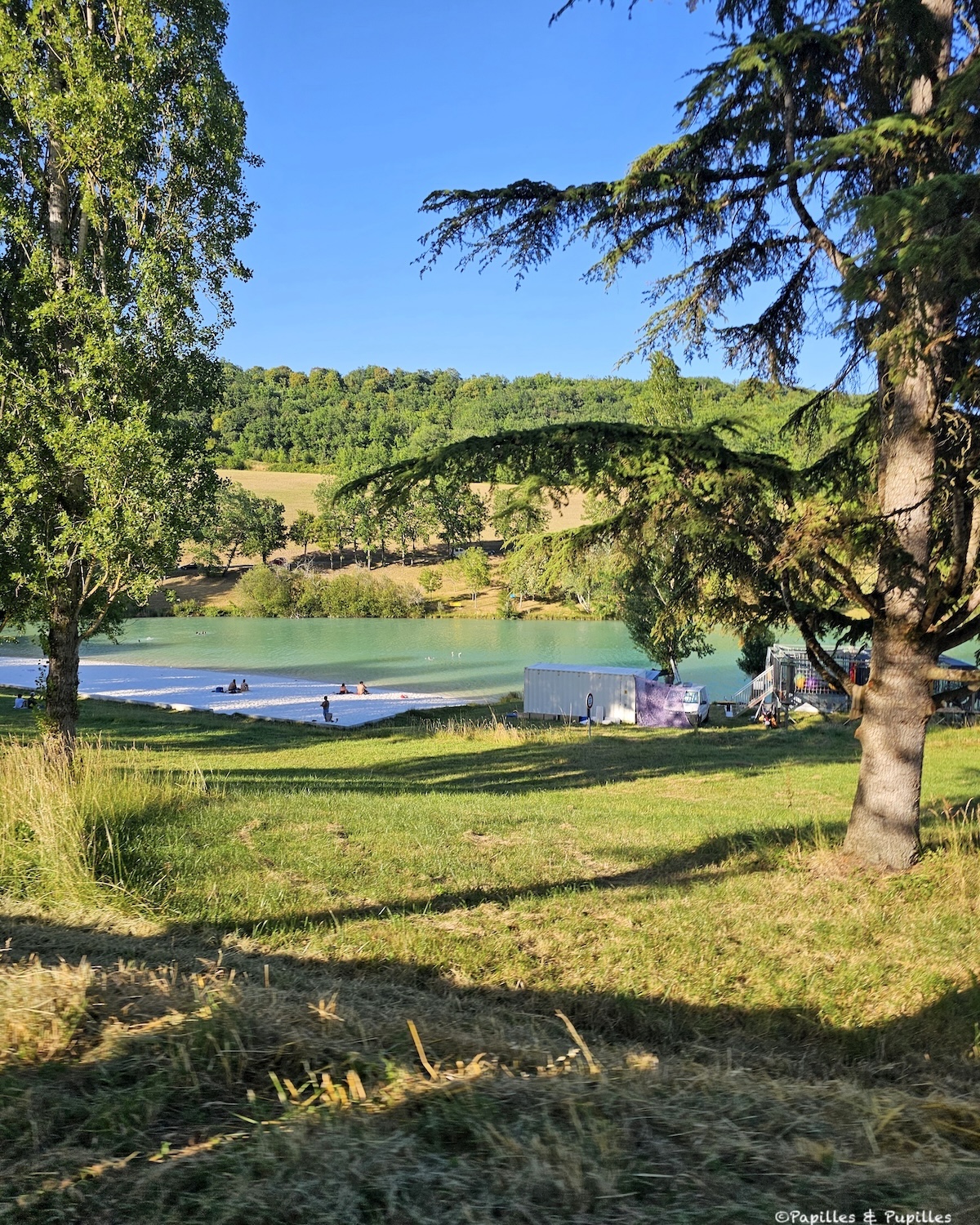 Lac de Montcuq entouré d’arbres et de collines dans le Lot