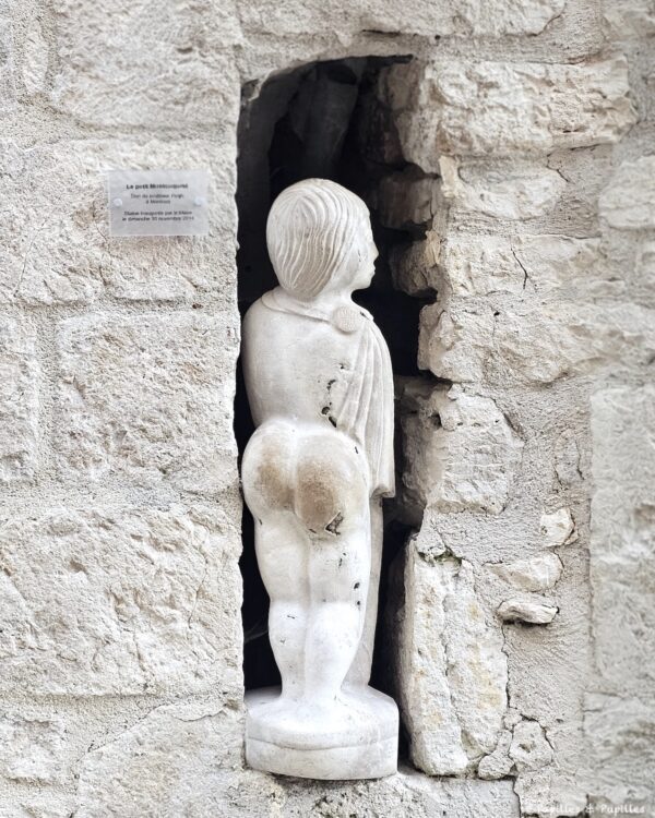 Statue du Petit Montcuquois dans une niche en pierre à Montcuq