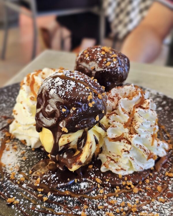 Profiteroles au chocolat avec glace vanille, chantilly et éclats de biscuit