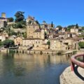 Puy-l’Évêque vu depuis les bords du Lot, avec maisons en pierre et reflets sur l’eau