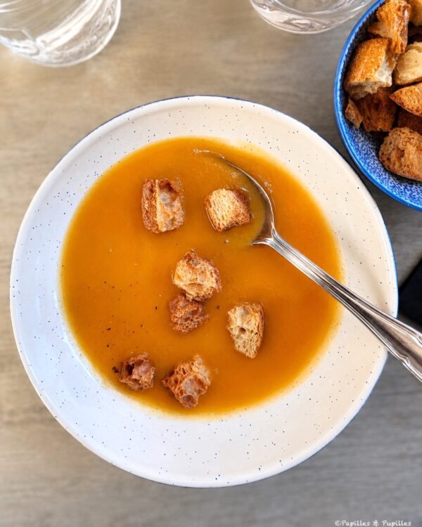 Potage carotte cumin avec croûtons de pain grillé dans une assiette creuse