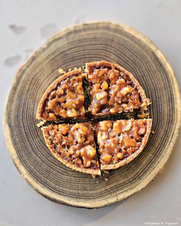 Tartelette aux noix découpée en parts sur un support en bois au restaurant Le 1862