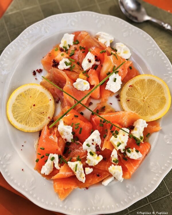 Assiette de truite et saumon fumés avec fromage frais, citron, ciboulette et baies roses