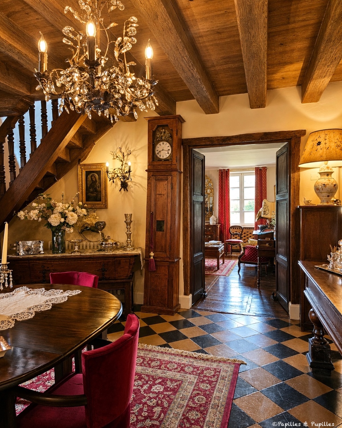 Salle à manger chaleureuse de la Maison Duler avec boiseries, tapis et lustre ancien